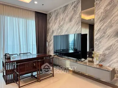 Elegant living room with modern decor and large TV, featuring floor-to-ceiling windows and stylish dining area.
