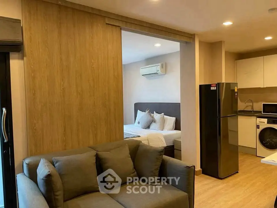 Modern studio apartment with cozy living area, compact kitchen, and comfortable bedroom.