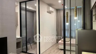 Modern studio apartment with glass partition, sleek lighting, and air conditioning.