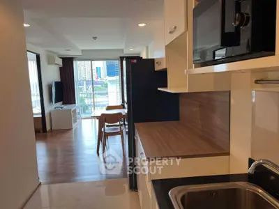 Modern open-layout apartment with sleek kitchen and spacious living area, featuring city views from the balcony.