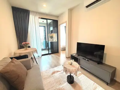 Modern living room with balcony access, featuring sleek furniture and natural light.