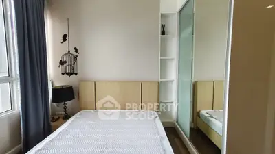 Modern bedroom with minimalist decor and large window for natural light.