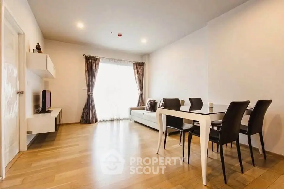 Spacious modern living room with elegant dining area and natural light.