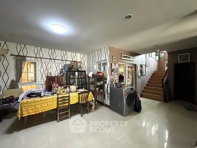 Spacious living area with modern decor and staircase, perfect for family gatherings.