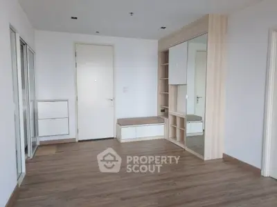 Spacious modern room with wooden flooring and built-in storage solutions.