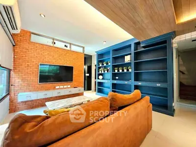 Modern living room with brick accent wall and built-in blue shelves
