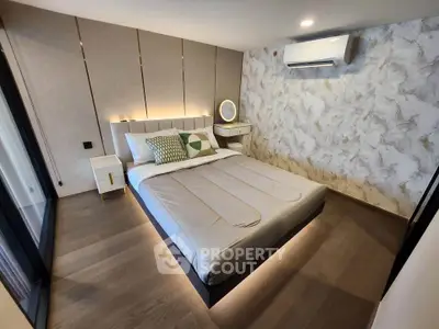 Modern bedroom with stylish decor and air conditioning, featuring a comfortable bed and elegant lighting.