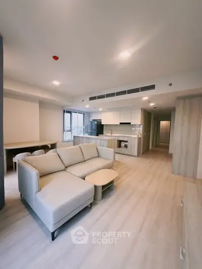 Modern open-plan living room with stylish kitchen and cozy sofa in a contemporary apartment.