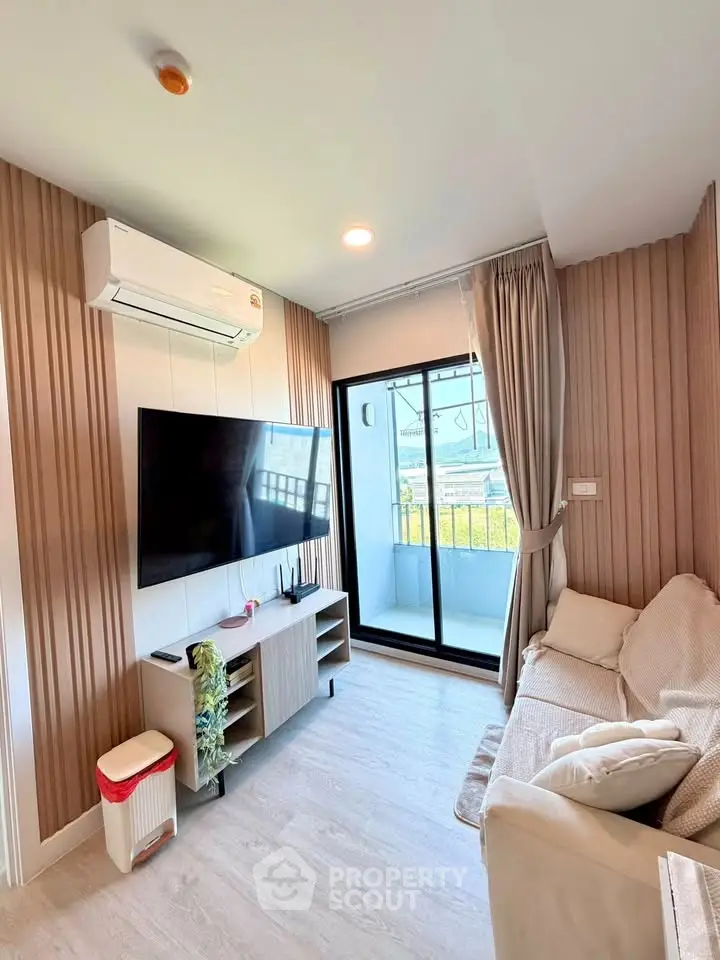 Modern living room with balcony access, featuring a wall-mounted TV and stylish decor.
