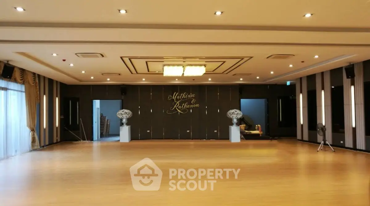 Spacious and elegant ballroom with modern lighting and wooden flooring.