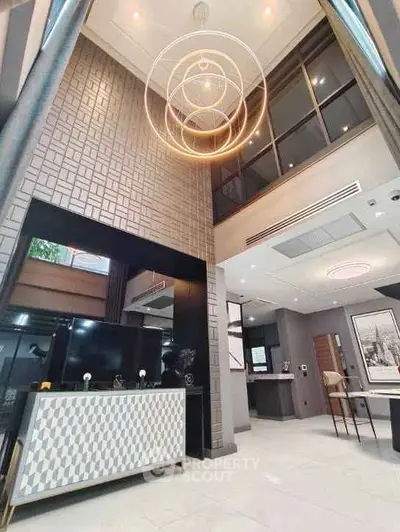 Luxurious modern living room with high ceilings and elegant lighting fixtures.