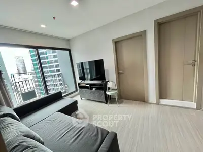 Modern living room with city view, featuring sleek furniture and large windows for natural light.