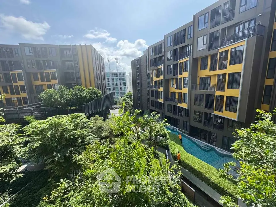 Modern apartment complex with lush greenery and vibrant yellow accents