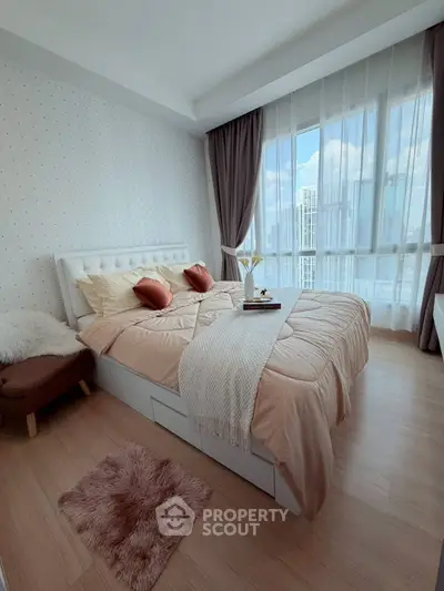 Cozy bedroom with elegant decor and large windows offering city views