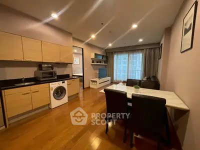 Modern open-plan kitchen and living area with wooden flooring and stylish furnishings.