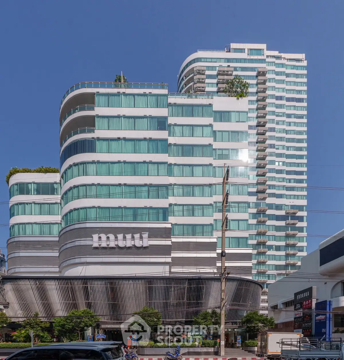 Modern high-rise building with unique architectural design and glass facade in urban setting.