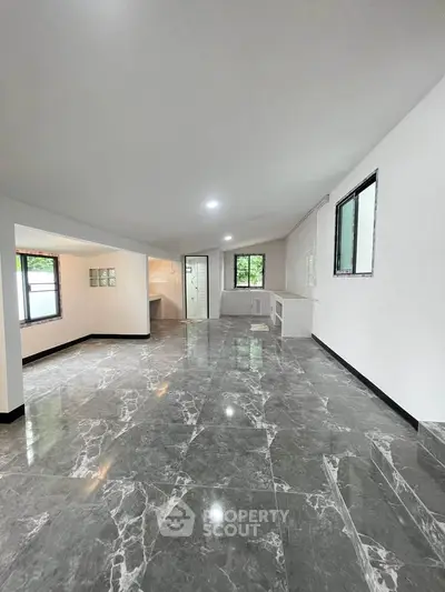 Spacious modern living room with marble flooring and large windows