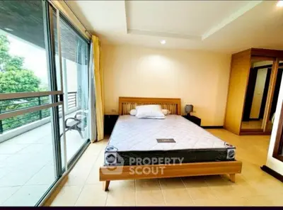 Spacious bedroom with balcony access and modern furnishings