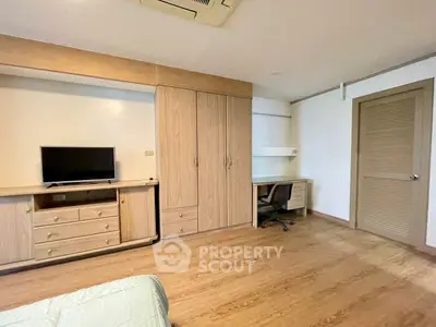 Spacious bedroom with built-in wardrobe and study desk in modern apartment