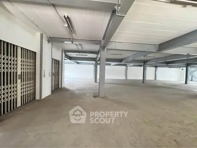 Spacious industrial warehouse with open floor plan and high ceilings, ideal for storage or manufacturing.