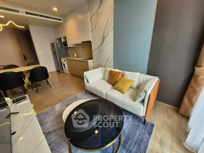 Modern living room with stylish decor, open kitchen, and cozy seating area in a contemporary apartment.