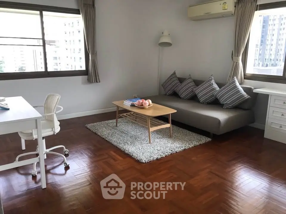 Spacious living room with modern decor and large windows in urban apartment.