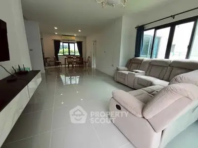Spacious modern living room with sleek tile flooring and plush seating, perfect for relaxation.