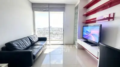 Modern living room with sleek black sofa, wall-mounted TV, and city view from balcony.