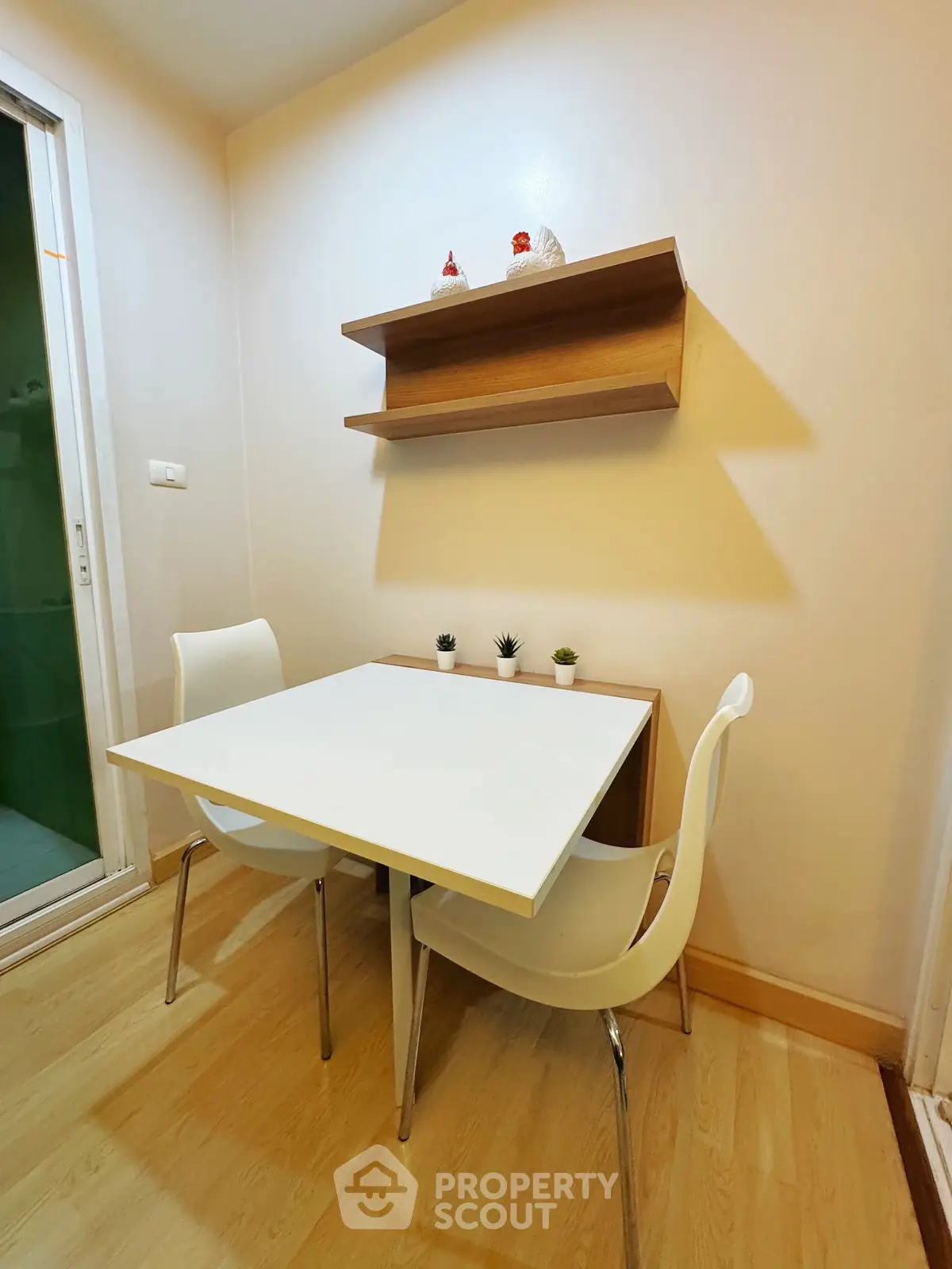 Cozy dining nook with modern white chairs and table, perfect for intimate meals.