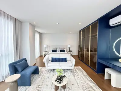 Luxurious modern bedroom with elegant decor and spacious layout, featuring stylish furniture and ambient lighting.