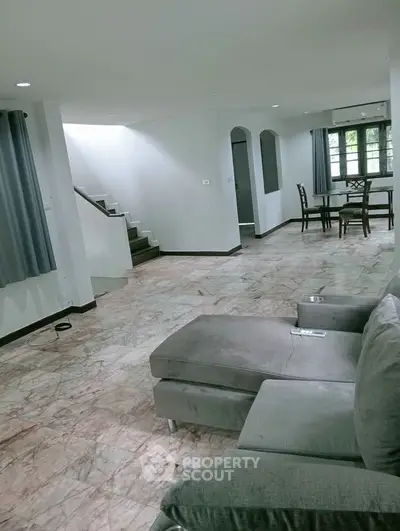 Spacious living room with marble flooring and modern furniture in a stylish home.