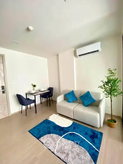 Modern living room with cozy sofa, dining area, and air conditioning in a stylish apartment.