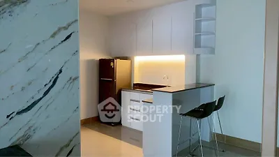 Modern kitchen with sleek cabinetry and breakfast bar in a stylish apartment.