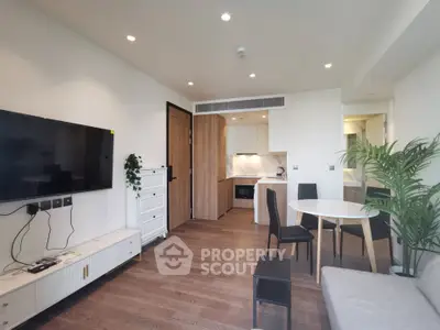 Modern living room with open kitchen, sleek furniture, and wooden flooring in a stylish apartment.
