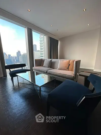 Luxurious living room with stunning city view, featuring modern furniture and floor-to-ceiling windows.