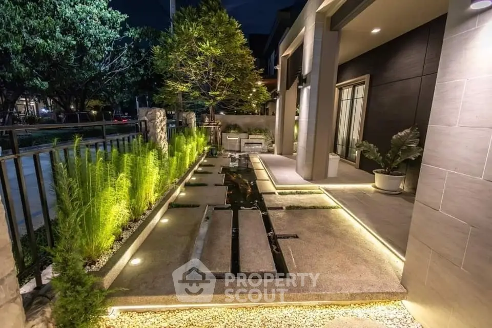 Stunning modern garden with ambient lighting and sleek design in a luxury property exterior.