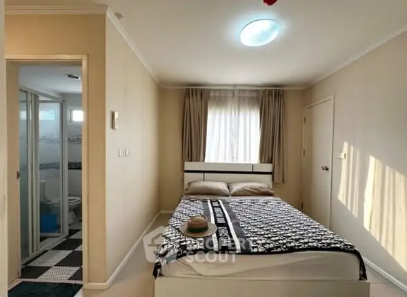 Cozy bedroom with ensuite bathroom, featuring natural light and modern decor.