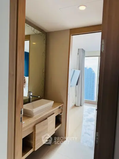 Modern bathroom with sleek vanity and city view from adjacent room