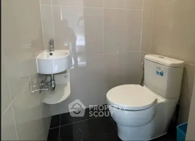 Modern bathroom with sleek fixtures and tiled walls in a real estate property.