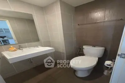 Modern bathroom with sleek fixtures and neutral tiles, perfect for a contemporary home.