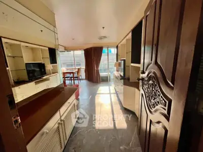 Spacious living room with elegant wooden door and ample natural light