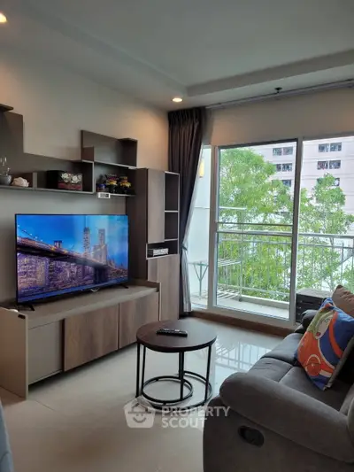 Modern living room with large TV and balcony view in stylish apartment