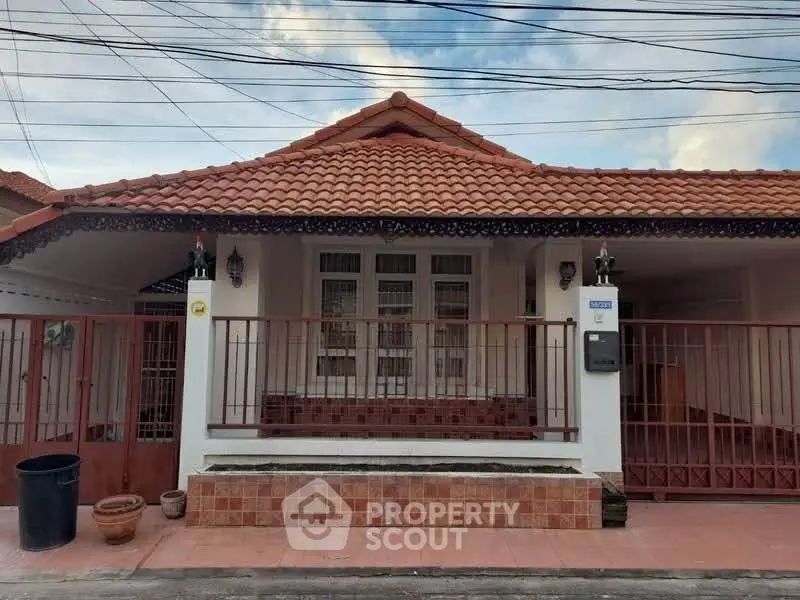 Charming single-story house with red tile roof and spacious front porch.