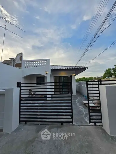 Charming single-story home with modern gate and spacious driveway, perfect for family living.