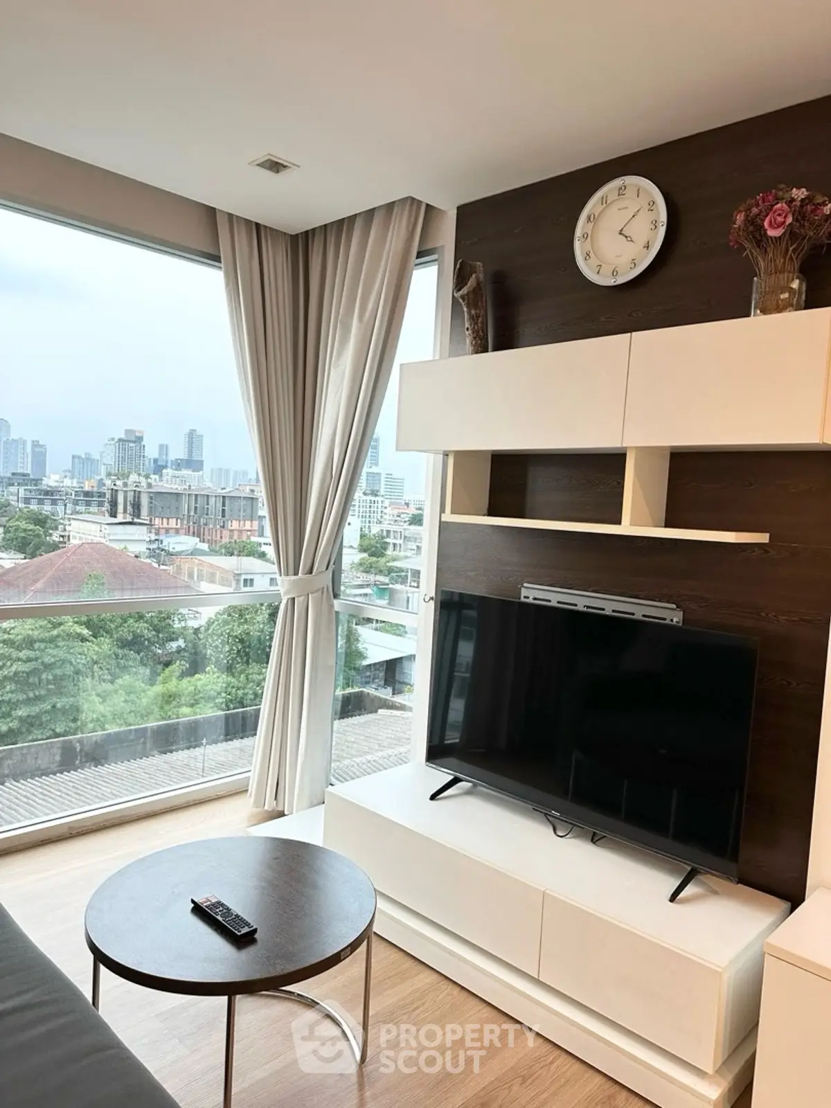 Modern living room with city view, large windows, and stylish decor