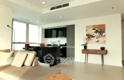Modern living room with open kitchen and stylish decor in a luxury apartment.