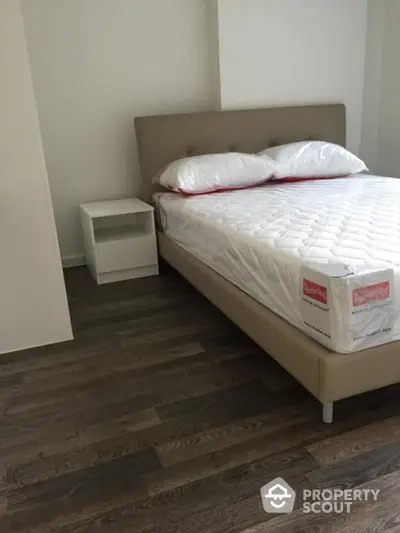 Modern bedroom with stylish bed and wooden flooring in a contemporary apartment.