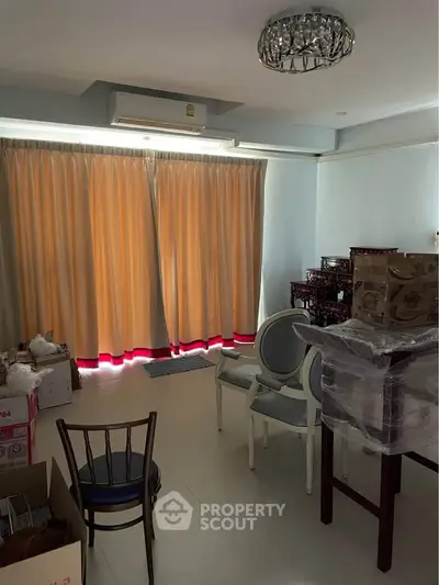 Spacious living room with large windows and elegant furniture, perfect for cozy gatherings.