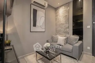 Modern living room with stylish decor and marble accents, featuring a cozy gray sofa and elegant artwork.