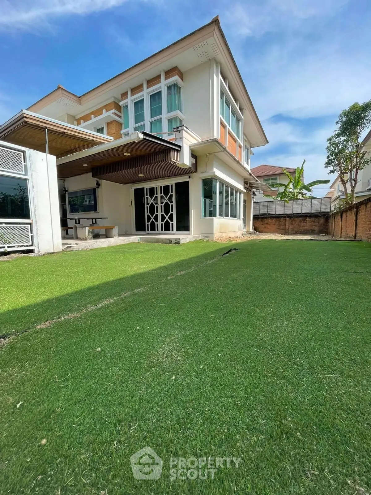 Spacious modern house with lush green lawn and elegant exterior design.